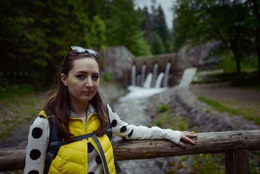Woman walking over wooden bridge in summer time
