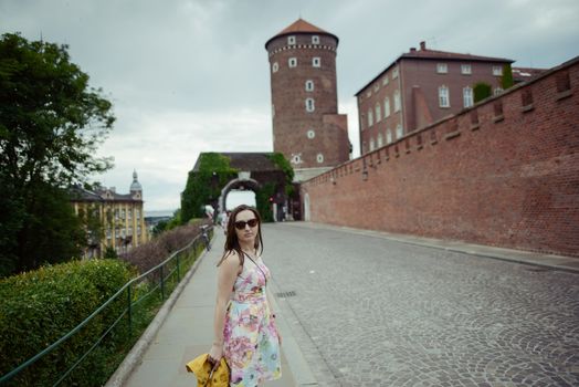Beautiful girl during sightseeing old castle in Cracow, Wawel. Summer time
