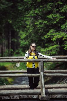 Woman walking over wooden bridge in summer time
