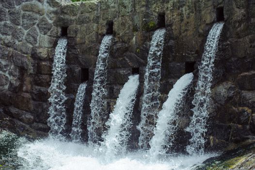 Mountain dam in summer on the small river in mountains