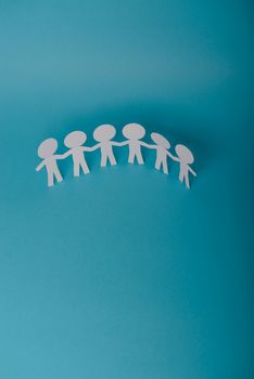 abstract paper people holding for hands on blue background