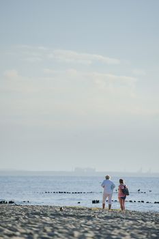 People walking on the beach in the ocean. Summer time
