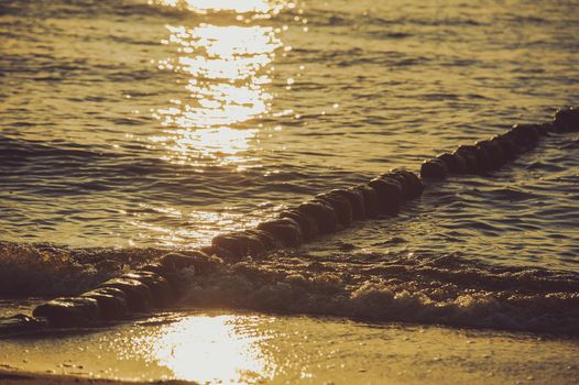 Breakwaters in the Baltic sea over the sunset in summer