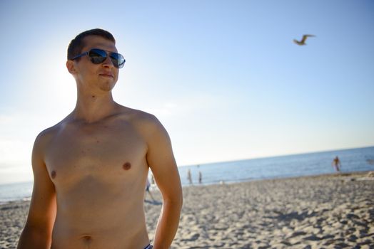 Young man finally at the beach without a t-shirt. Summer time