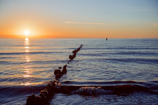 Breakwaters in the Baltic sea over the sunset in summer