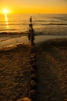Breakwaters in the Baltic sea over the sunset in summer