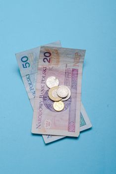 Polish zloty in notes and coins on blue background