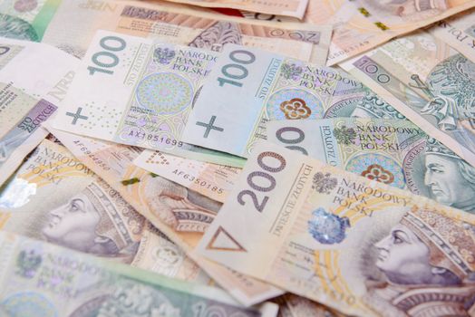 Polish zloty in notes and coins on red background