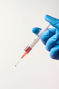 Hand in glove with syringe on white background. Injections.
