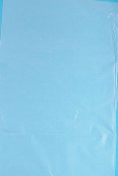 Plastic wrap on blue background, high resolution