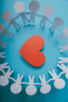 Red paper Valentines Day heart against a blue background