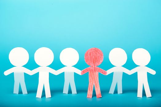 A group of red and white paper people holding hands indicating community support, partnership and togetherness.