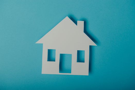 House shaped paper cutout on on blue background