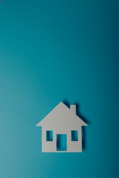 House shaped paper cutout on on blue background