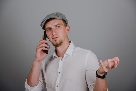 Portrait Of Happy Young Man Talking On Cell Phone Isolated On gray Background