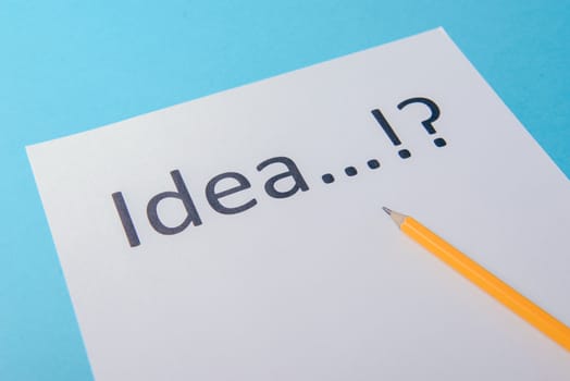 Idea word on white paper with pen. Blue background