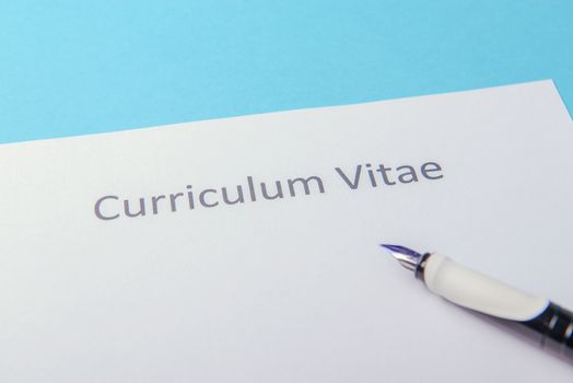 Curriculum vitae written on an blank white paper on blue background