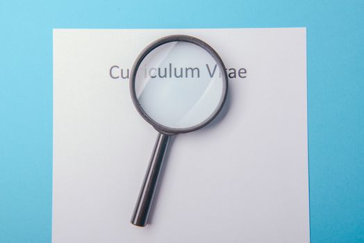 Curriculum vitae written on an blank white paper on blue background