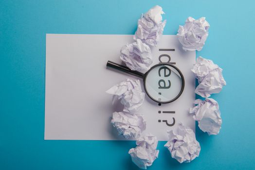 Idea word written on white paper. Blue background