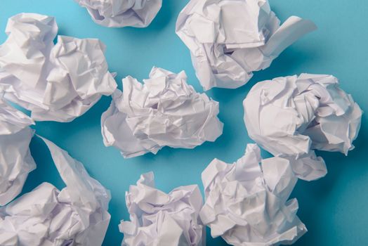 crumpled paper ball isolated on a blue background