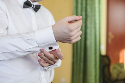 Man buttons on his shirt cuffs