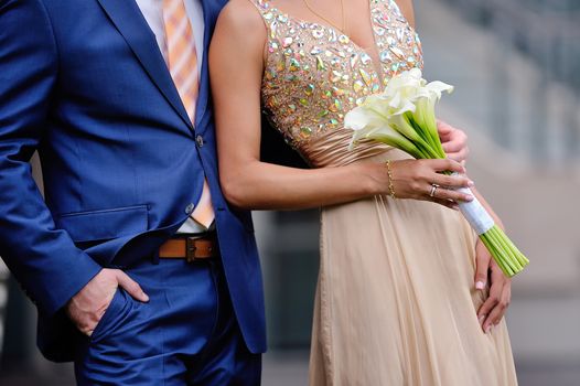 The groom embraces the bride 