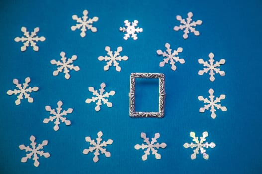 Christmas card with frame and snowflakes on a blue background