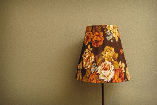 vintage Bedroom floor lamp glowing orange in a corner of a room 
