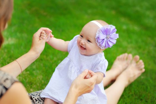 Beautiful happy little baby girl sitting on a green meadow  dandelions on the nature in the park 