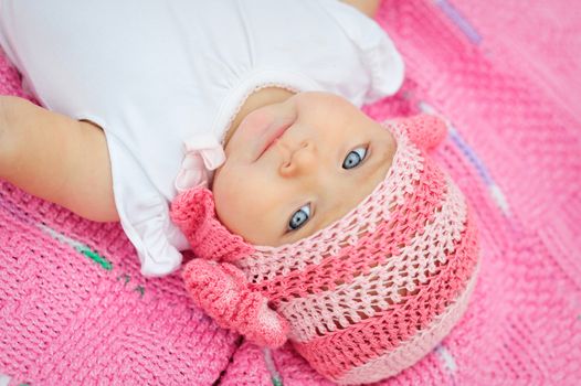 Charming child. Little girl in white knitted bear hat 