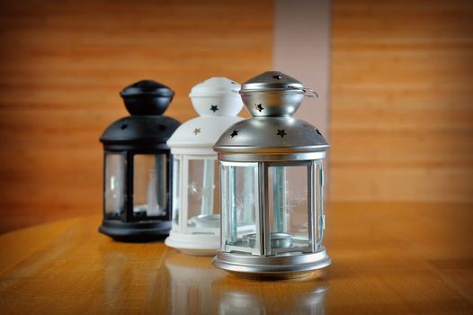 three beautiful lanterns made of glass and decorated with metal wire