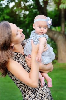 Happy mother and her little daughter in the summer field 