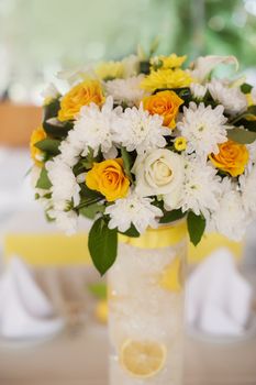 Bouquet of orange roses in a white wicker basket and vintage birdcage in the background 