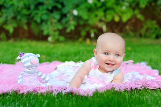 child, childhood and toddler concept - smiling baby lying on blanket and looking up 
