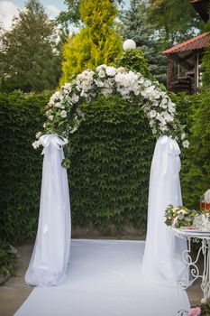 Arch and two white chairs in golf club prepared for weeding. Donetsk, Ukraine