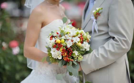 Bride holding wedding flower bouquet of white roses 