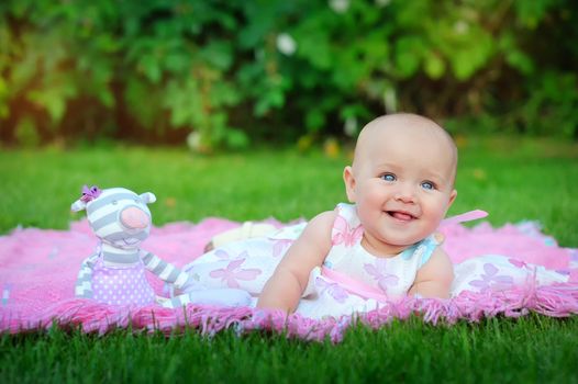 Baby lying on green grass in the park 