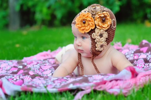 baby girl outdoors in a brown knitted cap
