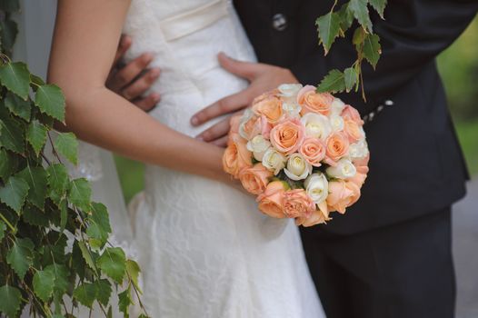 Bride is holding a wedding bouquet and a glass of champagne 