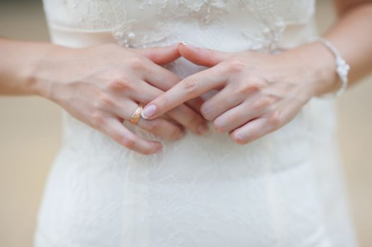 Hands of a bride at a wedding. pointing to the golden ring