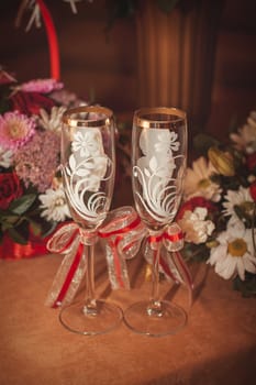 Two glasses and bouquet of the bride on a stone handrail 