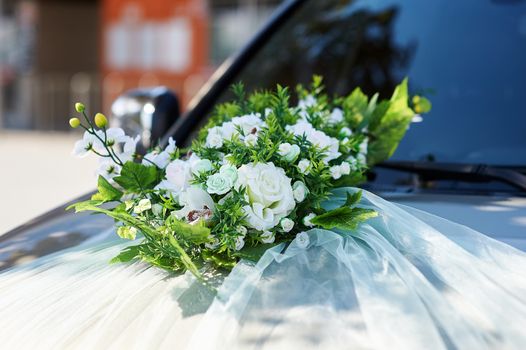 wedding car decorated with flowers on the hood.