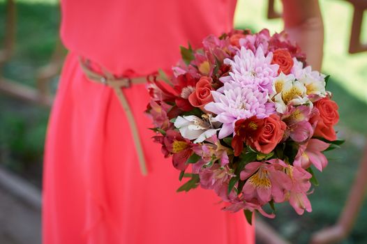 bridesmaids in a red dress with wedding bouquet.
