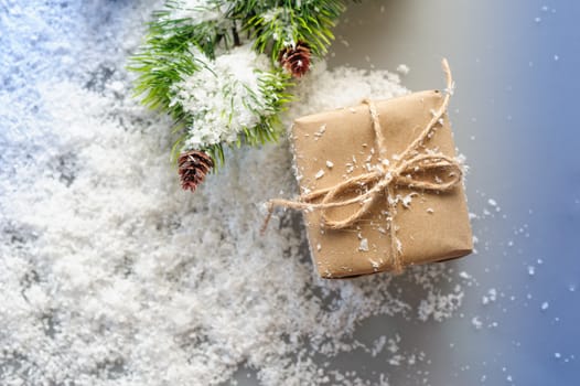gift box of kraft paper with spruce branches on white background.