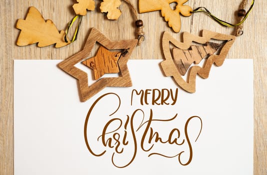 Wooden Christmas toys on a white background with text Merry Christmas. Calligraphy lettering