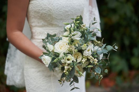 bride holding a beautiful bridal bouquet on walk