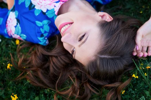happy young woman lying on green grass.