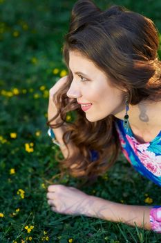 happy young woman lying on green grass.