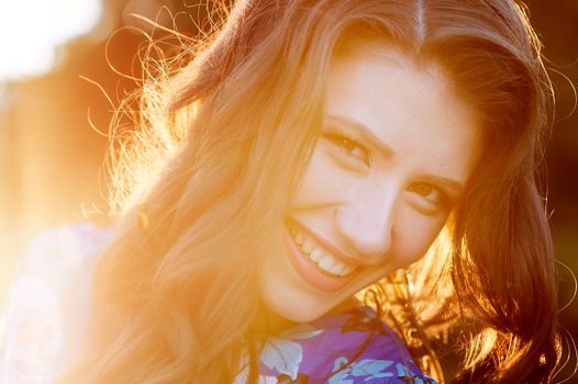 happy young woman on background of the glowing Sun close up.