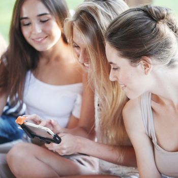 Portrait of girls chatting with their smartphones outdoors